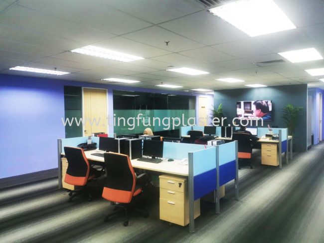 Modern office workspace with desks, computers, and corridor lighting.