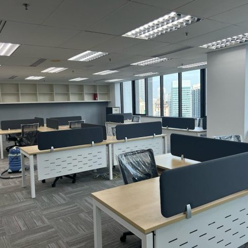 Fully furnished office with workstations, partitions, and chairs neatly arranged.