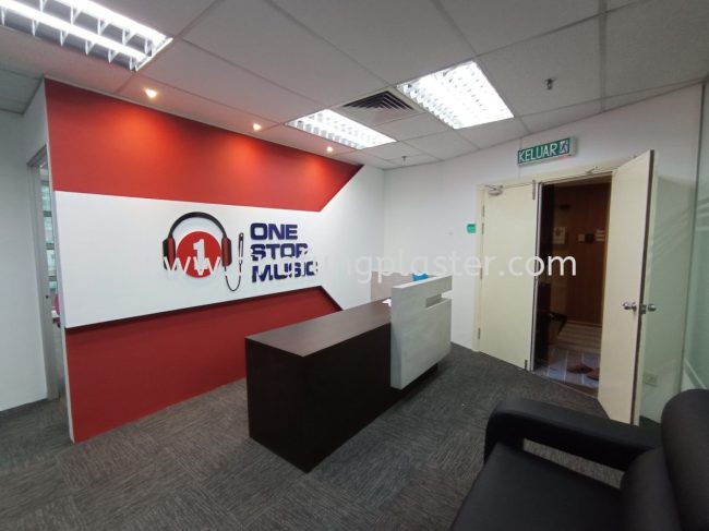 Reception desk in front of red-and-white “ONE STUDIO MUSIC” wall with exit door.