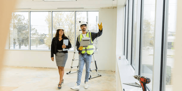 Construction supervisor discussing renovation timeline with office manager