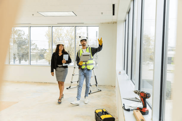 Construction supervisor discussing renovation timeline with office manager