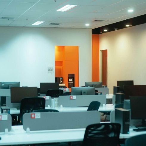 Newly set up computer lab with Dell desktops, organised rows of workstations, and orange accent walls