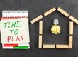 top view idea light bulb house shaped wood blocks time plan written notepad red green markers black